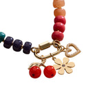 Multicolored beaded bracelet with gold charms on a white background