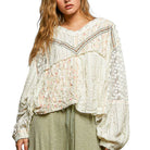 Woman wearing a floral blouse with long sleeves on a white background