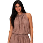 A woman modeling a sleeveless high-neck top and matching skirt in a dusty rose-brown lace fabric against a plain white background.