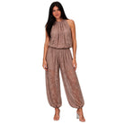 A woman modeling a sleeveless, high-neck harem-style jumpsuit in a dusty rose-brown lace fabric, set against a plain white background.