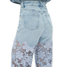 Light blue jeans with lace detailing on a white background