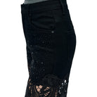Black pants with sequin and lace details on a white background