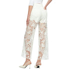White lace pants worn by a person on a white background