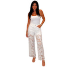 Woman wearing a white sleeveless top and lace-trimmed pants on a white background