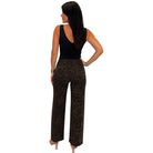 A woman shown from the back wearing a sleeveless black top and brown leopard-print pants against a plain white background.