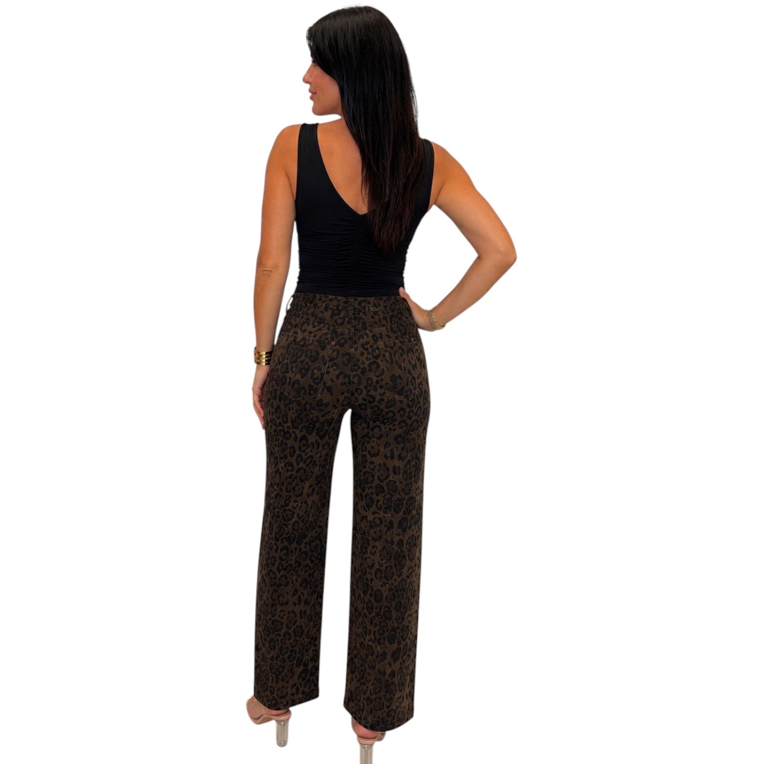 A woman shown from the back wearing a sleeveless black top and brown leopard-print pants against a plain white background.