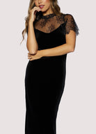 Black dress with lace details on a plain background