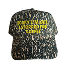 A baseball cap with a black, brown, and beige leopard print pattern, featuring yellow embroidered text on the front that reads 'SORRY I'M LATE, I STOPPED FOR COFFEE'.