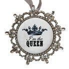 Decorative ornament with a crown and 'I'm the Queen' text on a wooden background