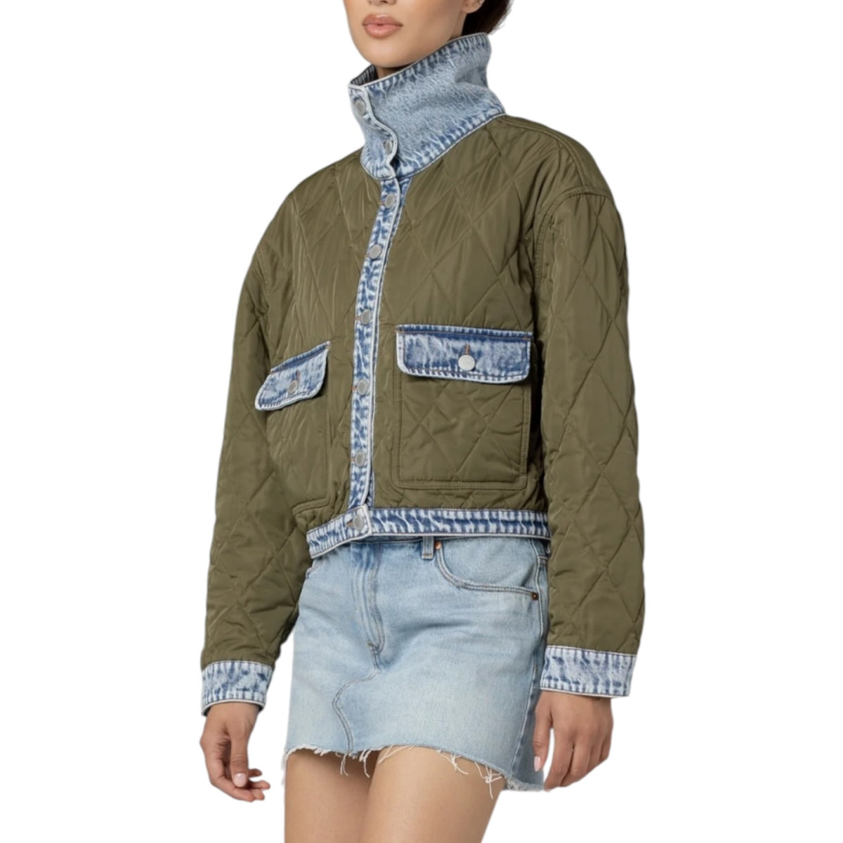 A model wearing a cropped quilted jacket in olive green with light blue denim trim, a high collar, and front flap pockets, paired with a light blue denim mini skirt against a plain white background.