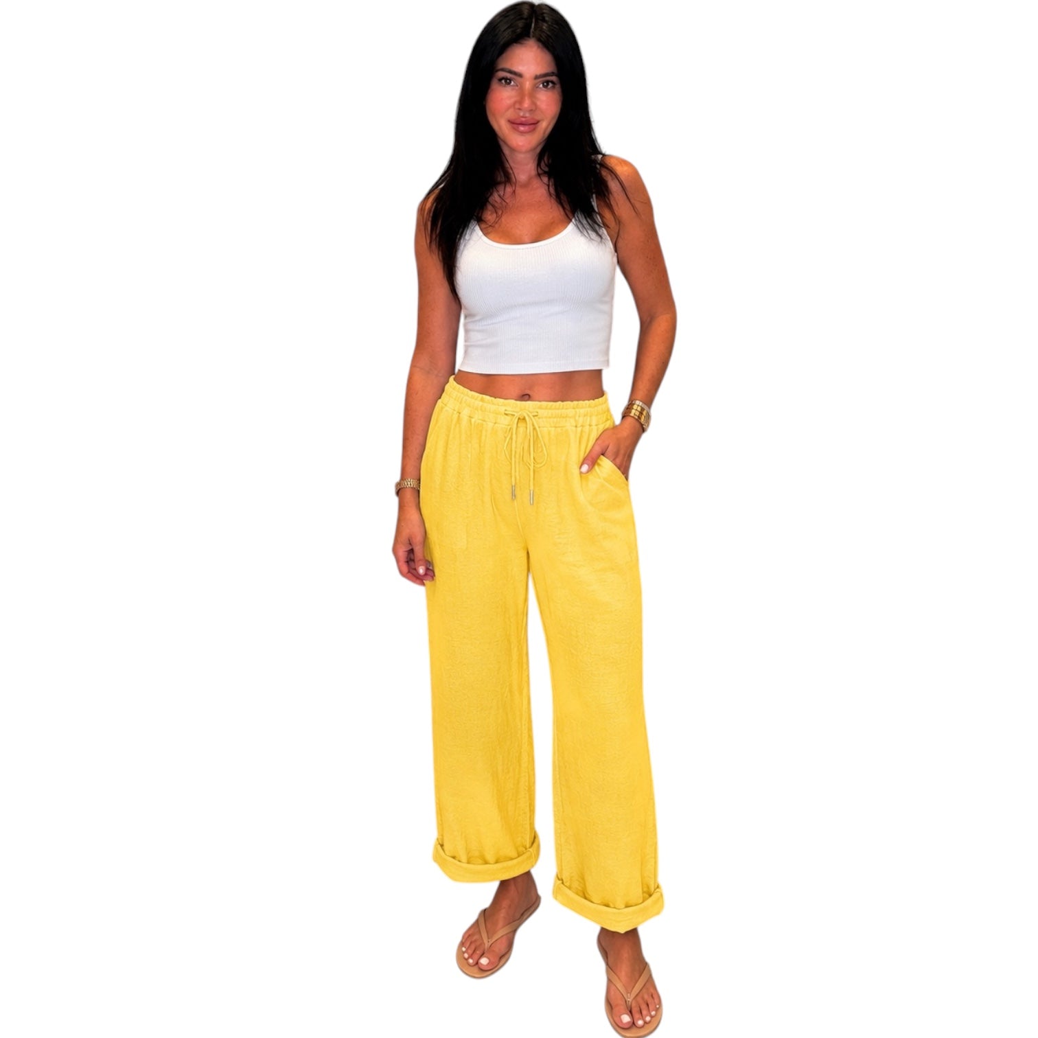 Woman wearing a white top and yellow pants on a white background