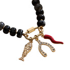 Bracelet with black beads and gold, red, and fish-shaped charms on a white background