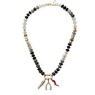 Necklace with black, white, and gold beads and a fish charm on a white background