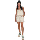 Person wearing floral shorts and green sneakers on a white background
