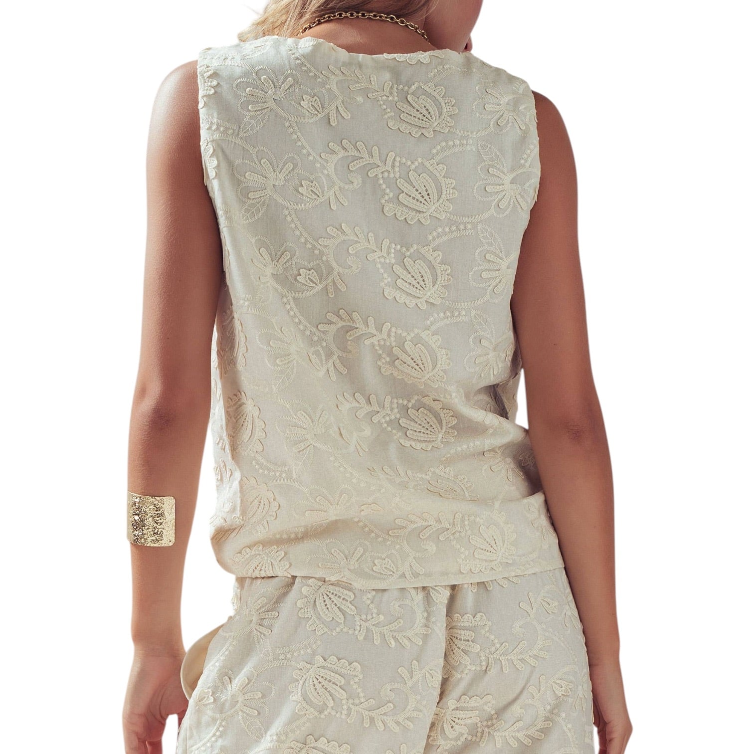 White embroidered sleeveless top and skirt set on a white background