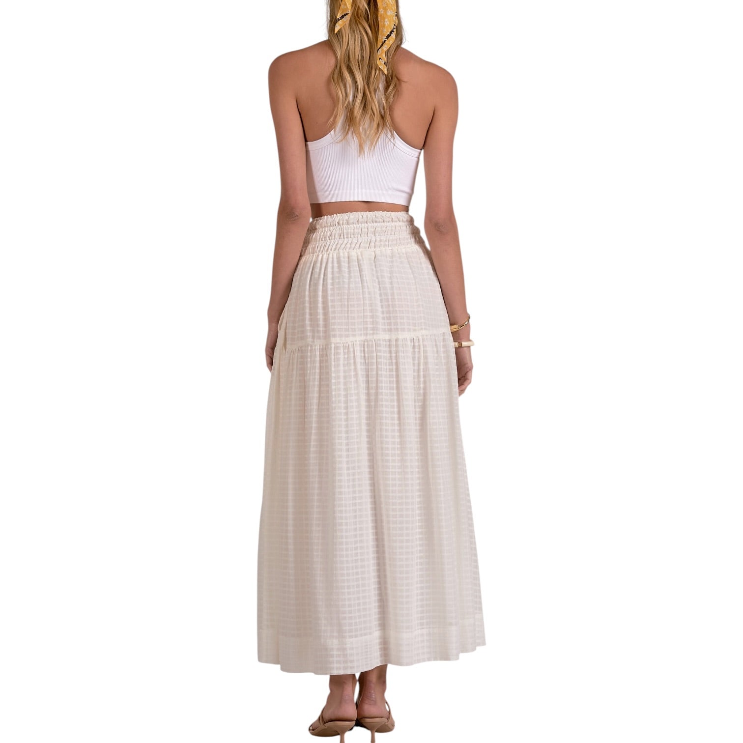 Woman wearing a white top and beige skirt on a white background