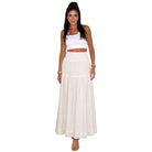 Woman wearing a white top and long white skirt on a white background