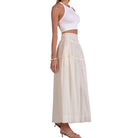 Woman wearing a white sleeveless top and beige checkered skirt on a white background
