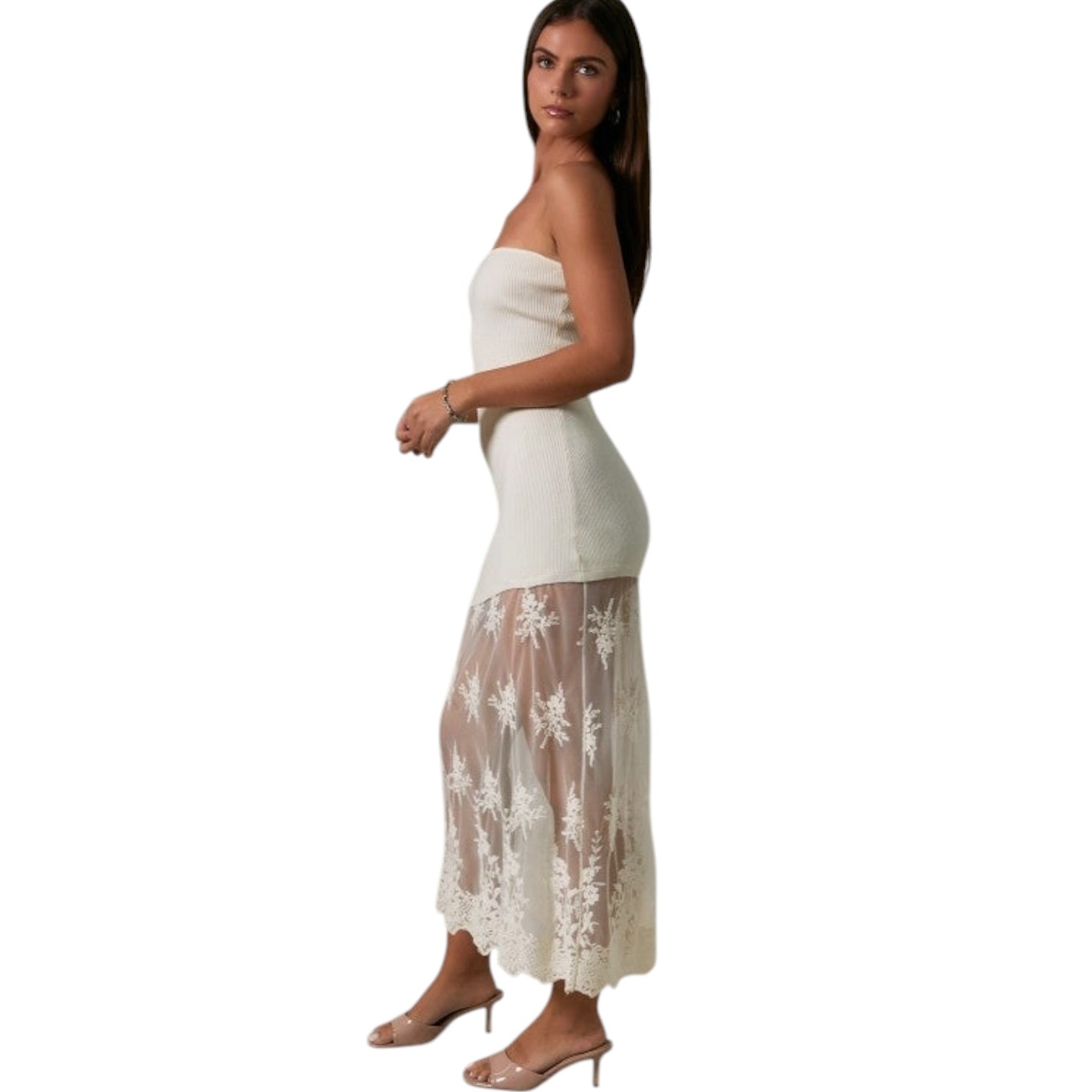 Woman wearing a strapless white dress with floral lace overlay on a white background