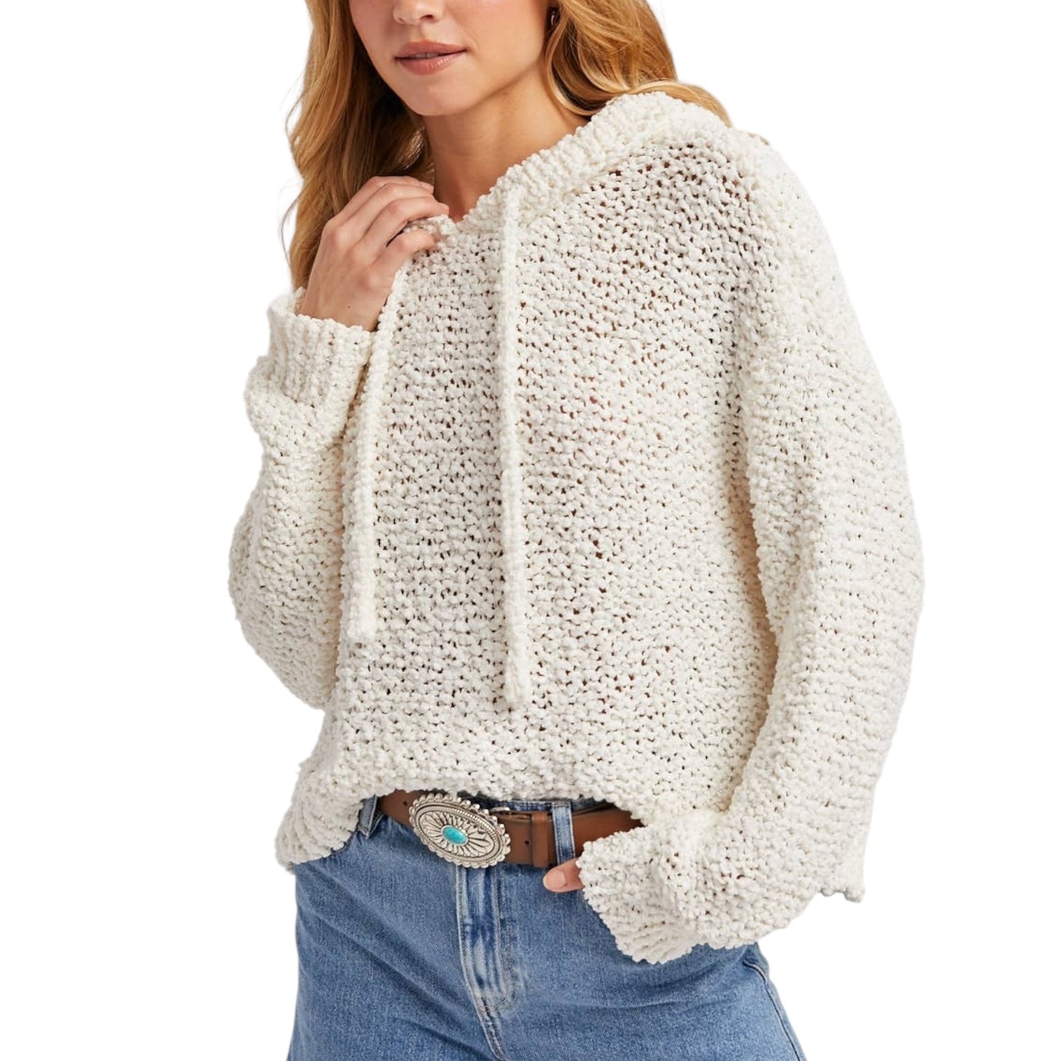 Woman wearing a chunky knit sweater and jeans on a white background