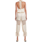 Beige jumpsuit with lace details on a white background