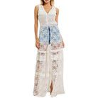 Woman wearing a ivory lace cover-up with denim shorts underneath on a white background
