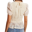 White blouse with puffed sleeves worn by a person on a white background