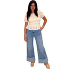 Woman wearing a white blouse and blue jeans on a white background