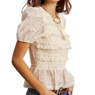 White lace top worn by a person on a white background