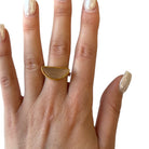 Gold ring on a finger with a plain background