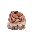 Set of three scrunchies in pink and beige on a light gray background