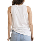 Woman wearing a white sleeveless top and light blue jeans on a white background