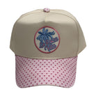 Beige cap with pink polka dot brim and embroidered logo on a white background