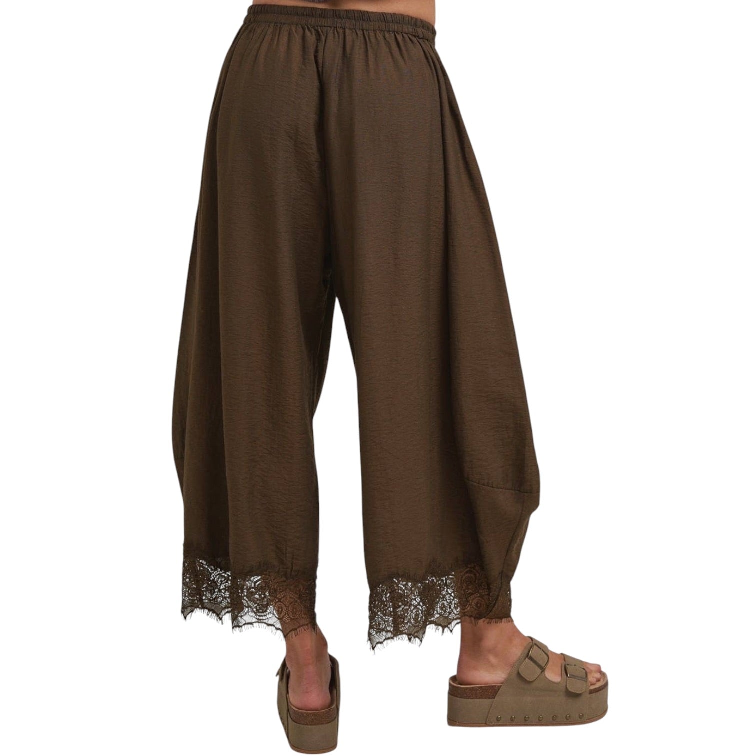 Brown wide-leg harem pants with a lace hem, shown on a model from the back wearing brown platform sandals against a white background.