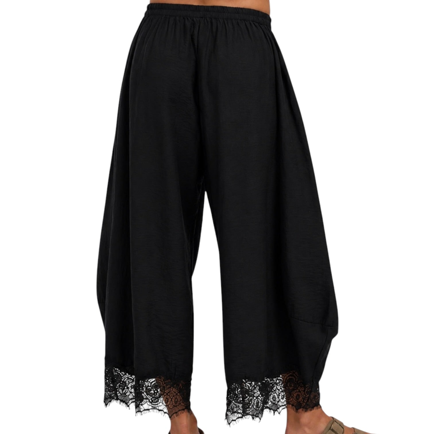 Black wide-leg harem pants with a lace hem, shown on a model from the back against a white background.