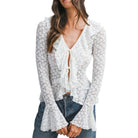 Woman wearing a white lace top with long sleeves on a white background