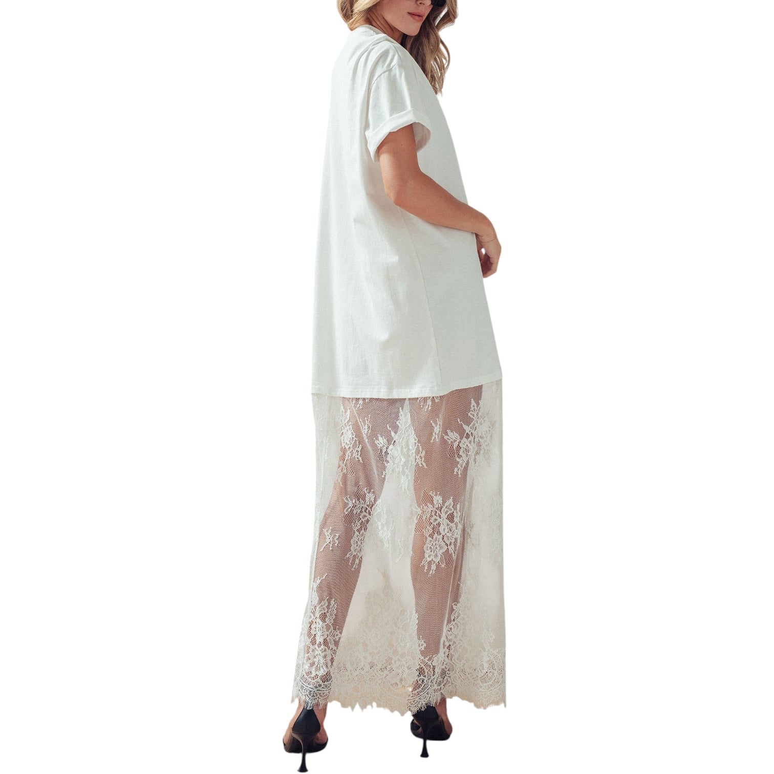 White dress with lace overlay worn by a model on a white background
