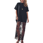 Woman wearing a black top and lace skirt on a white background