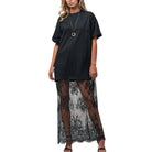 Black dress with lace overlay worn by a model on a white background