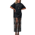 Black dress with sheer lace overlay worn by a mannequin on a white background