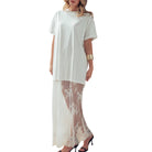 Woman wearing a white dress with lace detailing on a white background