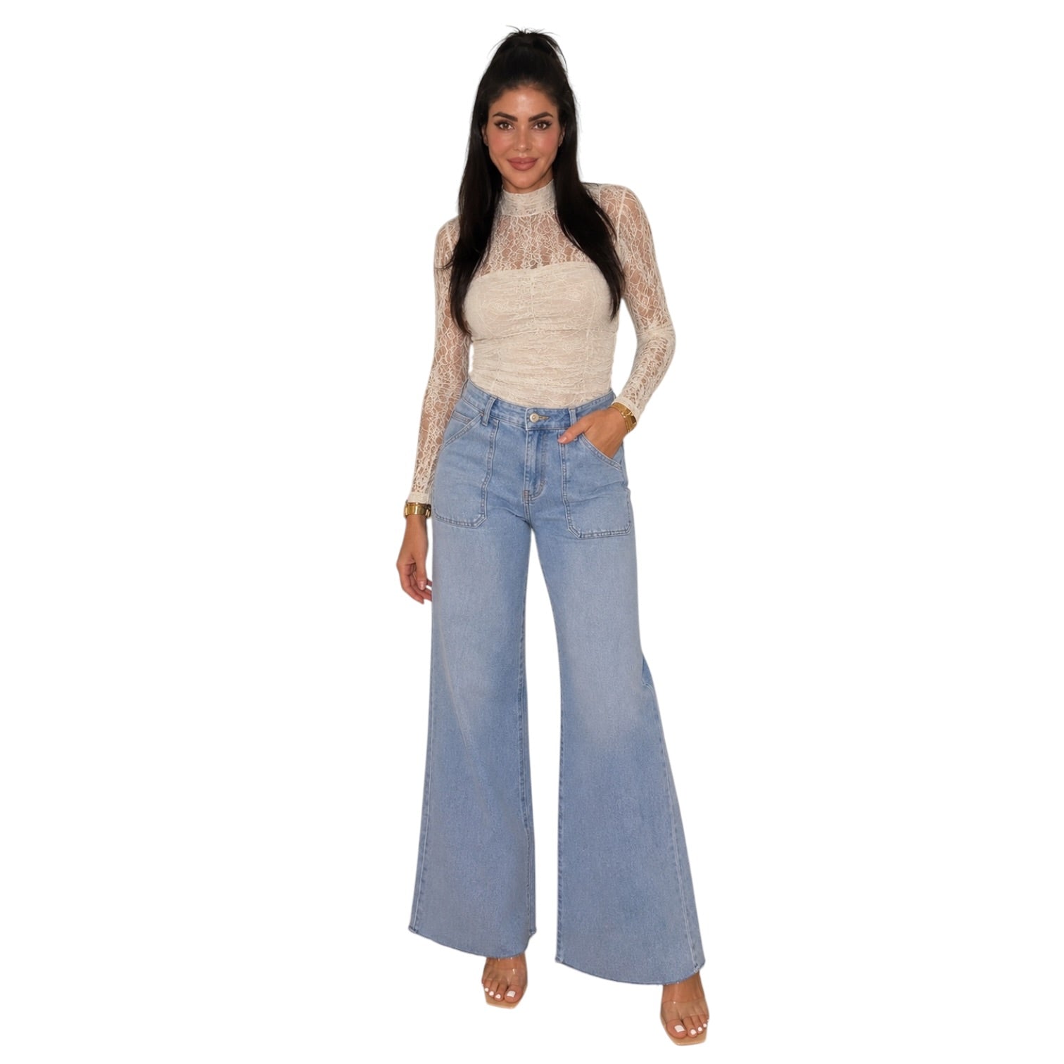 A woman modeling a cream lace long-sleeve top with light blue wide-leg denim jeans, standing against a plain white background.
