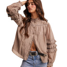 Woman wearing a beige lace-up blouse with a white background