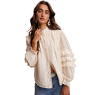 Woman wearing a white lace blouse with blue jeans on a white background