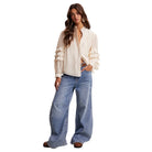 Woman wearing a white blouse and blue jeans on a white background