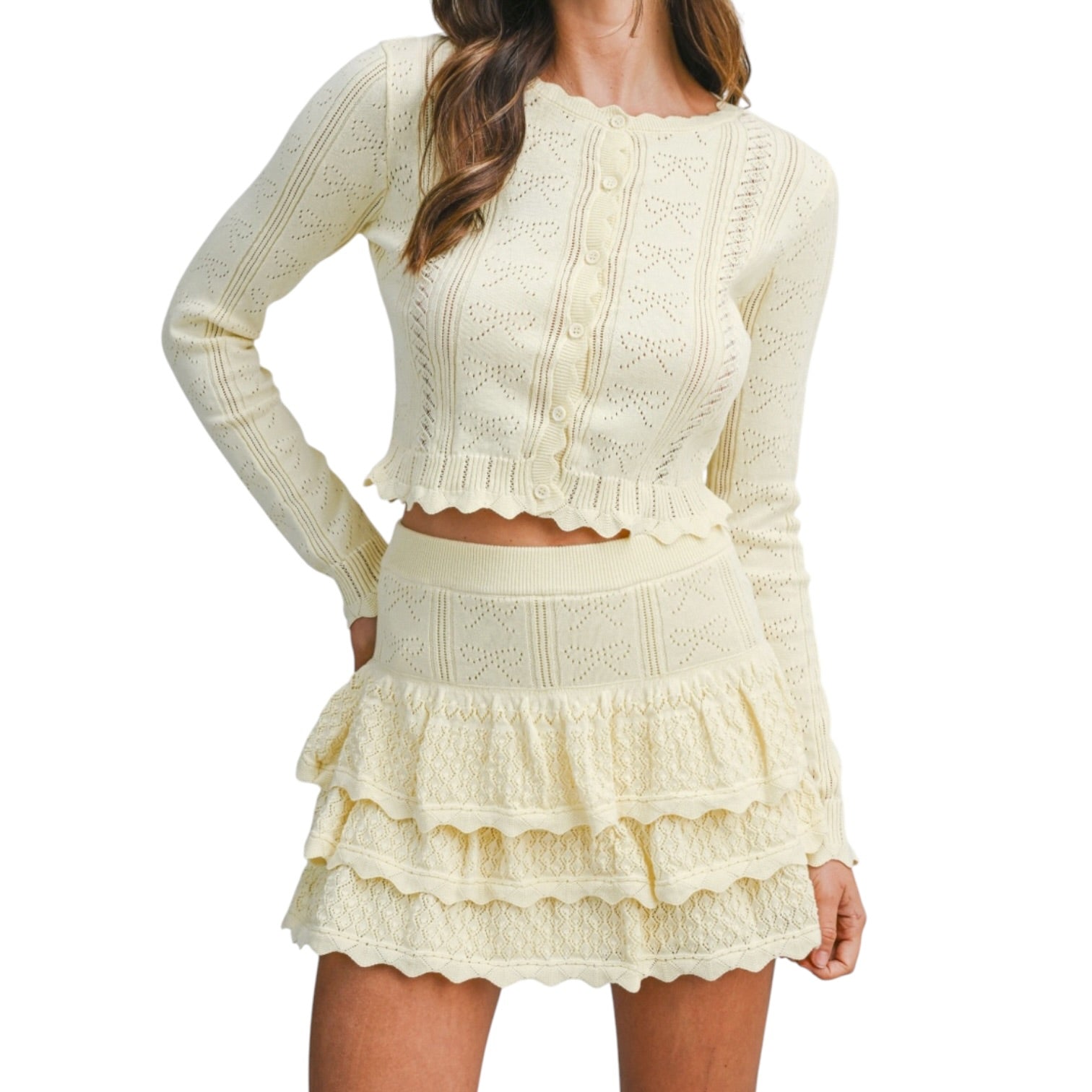 Woman wearing a lemon colored knitted set with a white background