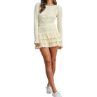 Woman wearing a lemon colored knitted set with a white background