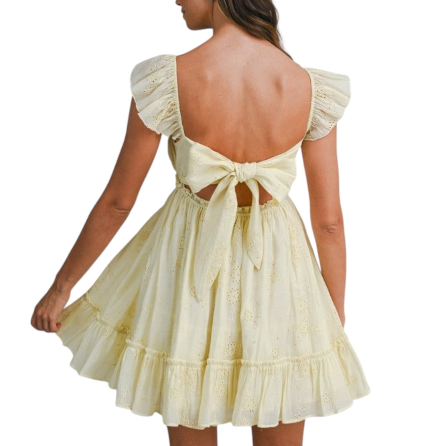 Woman wearing a light yellow dress with ruffled sleeves and a bow detail on a white background