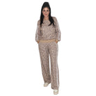 A woman modeling a matching two-piece lounge set with a beige and brown leopard print pattern, featuring a long-sleeve top with white side stripes and matching wide-leg pants.