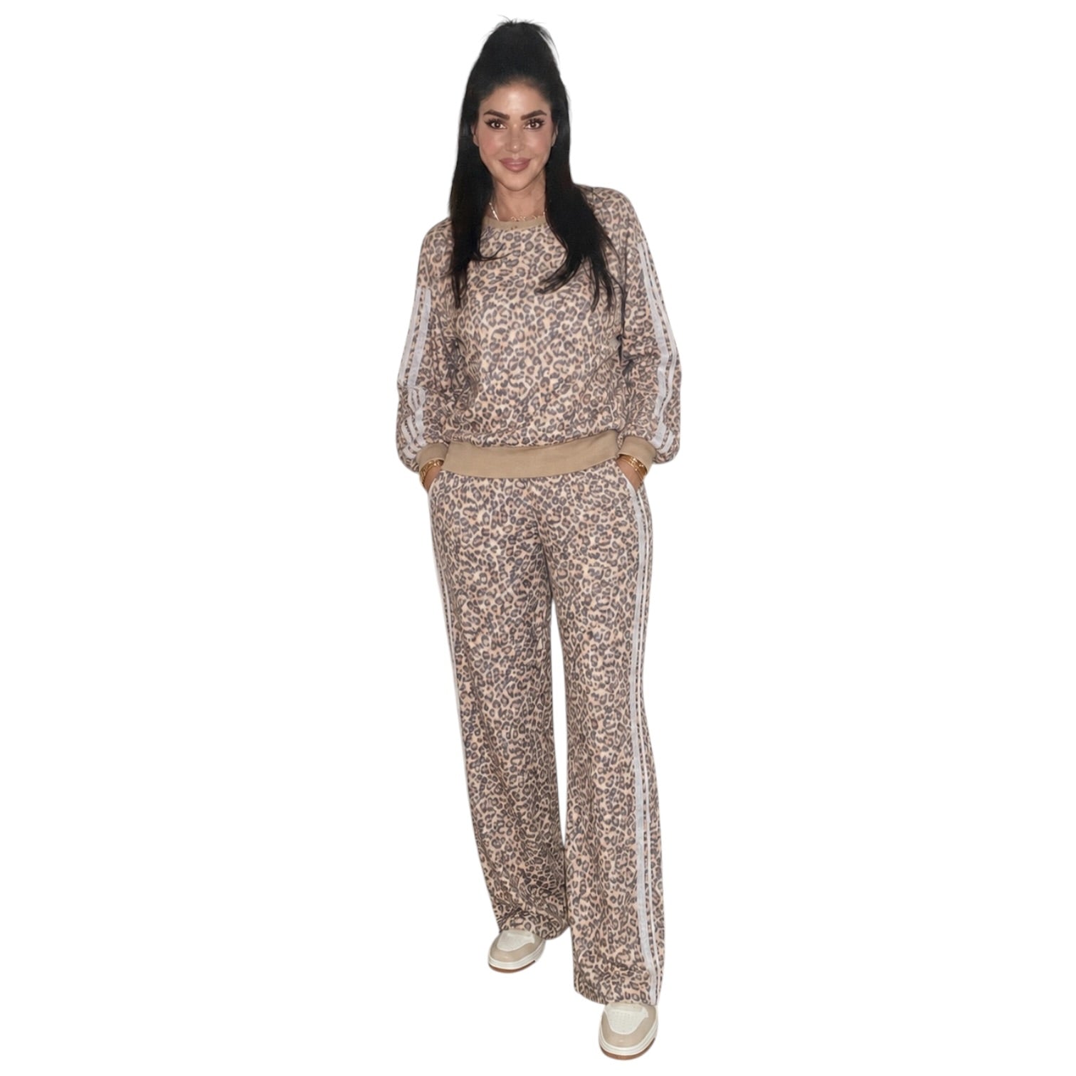 A woman modeling a matching two-piece lounge set with a beige and brown leopard print pattern, featuring a long-sleeve top with white side stripes and matching wide-leg pants.